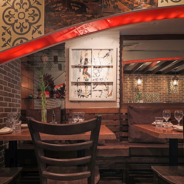 Cozy Balade Lebanese restaurant interior with brick walls, wooden tables, and patterned tiles.